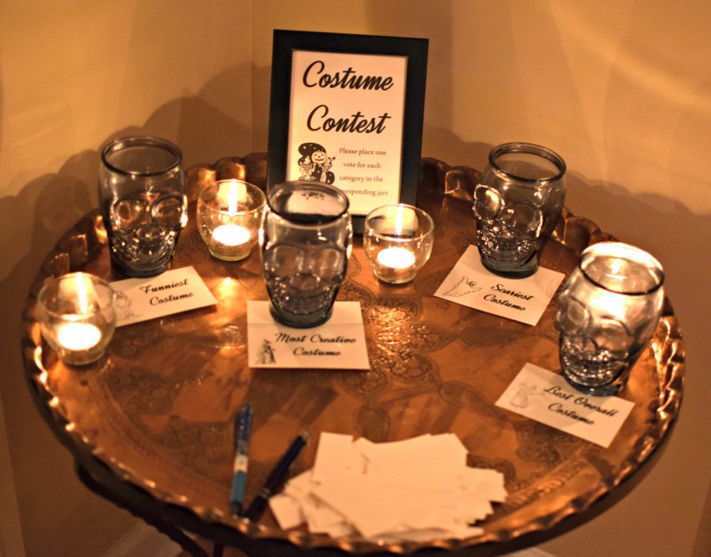 Need help hosting a halloween party? Check out this post for easy Halloween Decorations. For some extra fun throw a costume contest. These free Halloween party printables include a Pick you Poison sign, Costume Contest, and fillable halloween party food cards. 